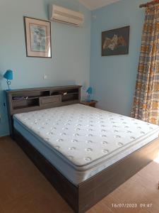 un letto in una camera con un grande materasso di Villa Evenik a Eretria