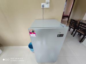 a white refrigerator in a room with a table and chairs at MUSLlM ONLY Wifi 3 Room with 2 aircond Menanti Village Homestay in Alor Setar