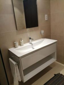 a bathroom with a white sink and a mirror at Blue Hawana in Salalah