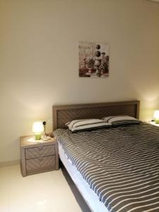 a bedroom with a bed and two tables with lamps at Blue Hawana in Salalah +16 photos