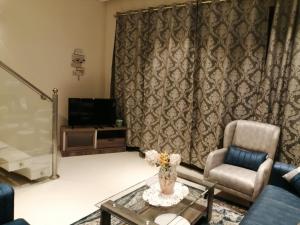 a living room with a couch and a chair and a table at Blue Hawana in Salalah
