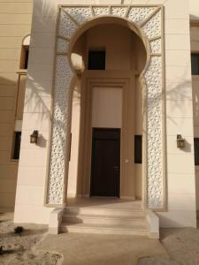 an entrance to a building with a black door at Blue Hawana in Salalah