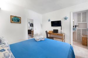 a bedroom with a blue bed and a desk at Faraglionensis MonaconeHouse Apartment in Capri