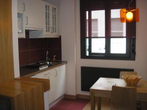 una pequeña cocina con mesa y ventana en Alojamientos Maramar, en Candás
