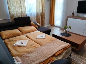 a living room with a large bed and a table at Shine Apartman in Szentgotthárd