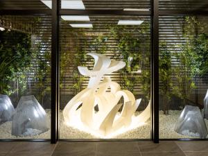 una escultura iluminada delante de una puerta de cristal en La'gent Hotel Kyoto Nijo en Kyoto