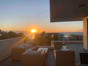 格兰贝伊PENTHOUSE VUE MER - MONT CHOISY的阳台的日落美景和海景