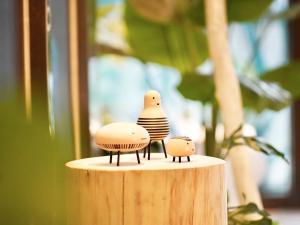 dos pájaros de juguete sentados en la parte superior de un tocón de madera en Finders Hotel Hualien Da-Tong en Hualien