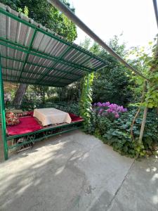 a bed under a canopy in a garden with flowers at Lovely home in Osh