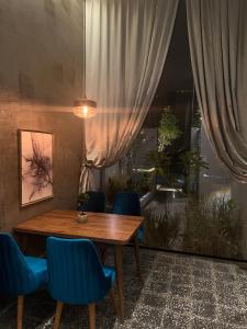 ein Esszimmer mit einem Holztisch und blauen Stühlen in der Unterkunft شاليهات كورال بارك in Al Kura