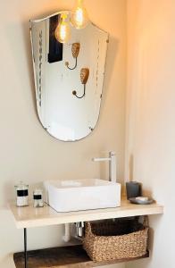 een badkamer met een wastafel en een spiegel bij Les Balcons du Luberon in Apt