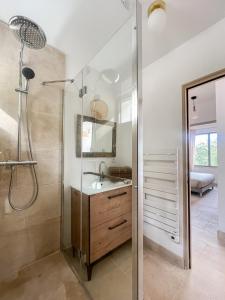 un bagno con doccia, lavandino e specchio di La Mirande à Lacoste a Lacoste