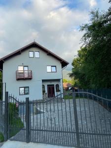 a white house with a fence in front of it at Casa Moșoiu in Bran