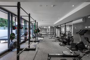 Samma Flagstaff Luxury Apartments في ملبورن: صالة ألعاب رياضية مع العديد من أجهزةالجري والأجهزة في الغرفة