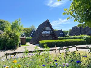 a house with a garden in front of it at Nurdachhäuschen Blaue Nordseewelle in Carolinensiel