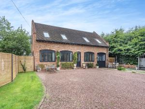 a brick house with a fence and a yard at Dower House Lodge in Lindridge