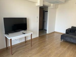 a living room with a tv on a table and a couch at Antalya apartment in Antalya