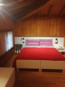 a bedroom with a large bed with a red blanket at B&B Mirò in Pieve di Soligo
