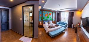 ein Schlafzimmer mit einem Bett, einem Sofa und einem Spiegel in der Unterkunft Jade Scene Hotel in Hue