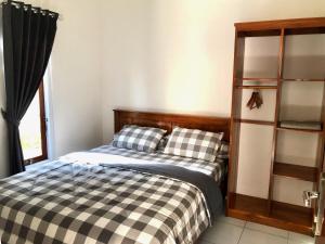 a bedroom with a bed and a book shelf at LOPE HOMESTAY in Ndangu