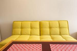 a yellow couch in a room with a red rug at Studio Treti Mart South in Primorsko