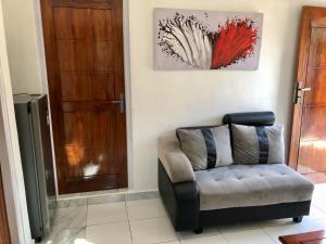 a living room with a couch and a door at LOPE HOMESTAY in Ndangu