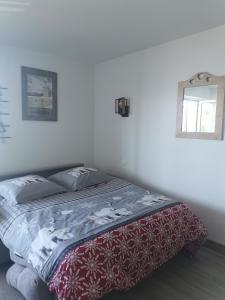 - une chambre dotée d'un lit avec une couverture rouge et blanche dans l'établissement LES BALCONS DU SOLEIL L OURSON, à Font-Romeu-Odeillo-Via