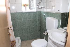 ein Badezimmer mit Toilette und Waschbecken in der Unterkunft Vila Apartment in Poljica + 19 Fotos