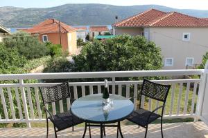 einen Glastisch mit einer Flasche Wein auf dem Balkon in der Unterkunft Vila Apartment in Poljica