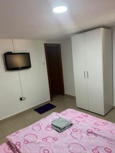 代斯波托瓦茨的住宿－ŽUBOR VRELA，卧室配有粉红色的床和墙上的电视。
