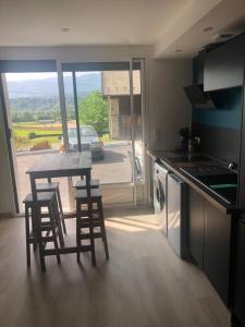 a kitchen with a table and chairs and a view of a street at Appartement au cœur de la Savoie in Saint-Jean-de-la-Porte