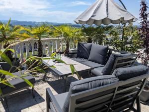 um pátio com uma mesa, cadeiras e um guarda-sol em Apart Hotel near Lucerne em Ruswil