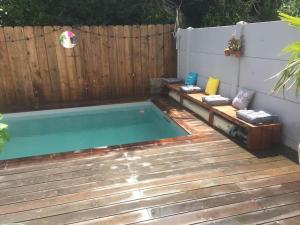 a swimming pool in a backyard with a wooden fence at Maison, piscine centreville Gujan-Mestras 4 hôtes in Gujan-Mestras