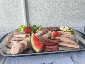 einen Teller mit Fleisch und Obst auf dem Tisch in der Unterkunft Studiotel TOP LOFT in Düsseldorf