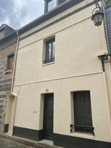 - un bâtiment blanc avec deux portes et deux fenêtres dans l'établissement GITE DE FAMILLE, à Dieppe