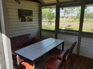 a table and chairs in a screened in porch at Pas danielius in Ramučiai