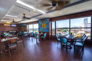 a dining room with tables and chairs and windows at Jade Scene Hotel in Hue