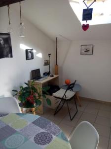 Zimmer mit einem Tisch und einem Schreibtisch mit einem Laptop in der Unterkunft WELLCOME#HOME in Aramon