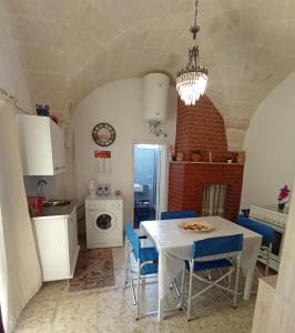 une cuisine avec une table blanche et des chaises bleues dans l'établissement CASA VACANZA NONNA EMMA, à Lizzano