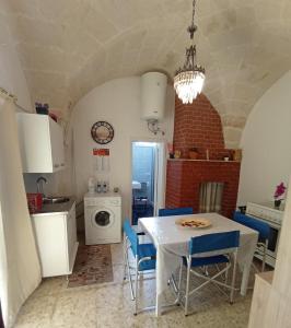 a kitchen with a white table and blue chairs at CASA VACANZA NONNA EMMA in Lizzano
