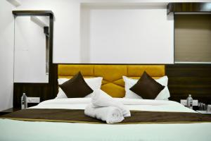 Una cama grande con toallas blancas encima. en Hotel Royal Ican Sindhu Bhavan Road en Ahmedabad