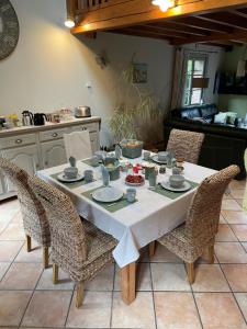 a dining room table with chairs and a white table cloth at La Paulerie in Wacquinghen