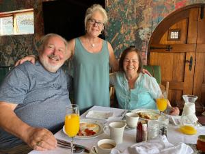 a group of three people sitting at a table at La Pension Guest House in Oudtshoorn