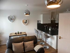 a living room with a couch and a kitchen at Perfectly situated luxury 2 bedroom apartment in Glasgow