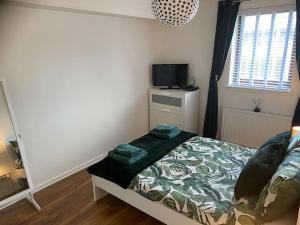 a small bedroom with a bed and a television at Perfectly situated luxury 2 bedroom apartment in Glasgow