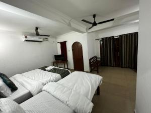 a living room with two beds and a couch at Seaway inn guesthouse in Baga
