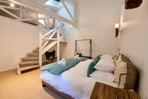 a bedroom with a bed in a room with a staircase at Au Ralenti du Lierre in Beaumettes +50 photos