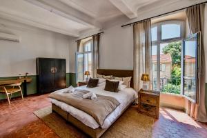 a bedroom with a large bed and a large window at Au Ralenti du Lierre in Beaumettes