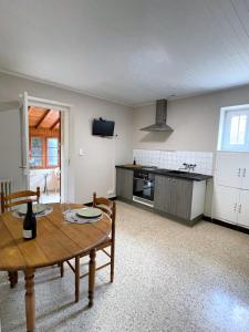 uma sala de estar com uma mesa e uma cozinha em Maison au pied de la Roche em Solutré-Pouilly