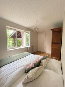 uma cama grande num quarto com duas janelas em Maison au pied de la Roche em Solutré-Pouilly